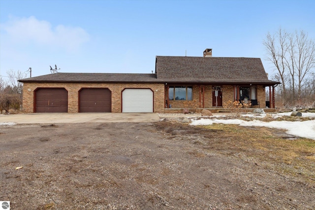 view of front of home with a garage, a chimney, concrete driveway, and brick siding