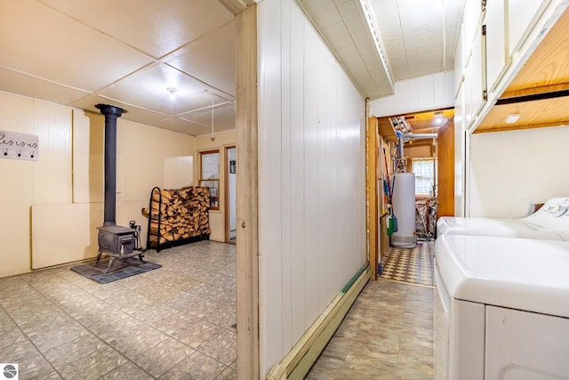 laundry room featuring cabinet space, a baseboard radiator, tile patterned floors, washing machine and clothes dryer, and water heater