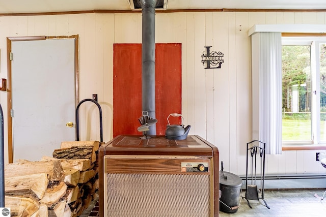 room details featuring a wood stove, baseboard heating, and wood finished floors