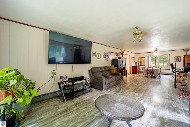 living room with ornamental molding and wood finished floors