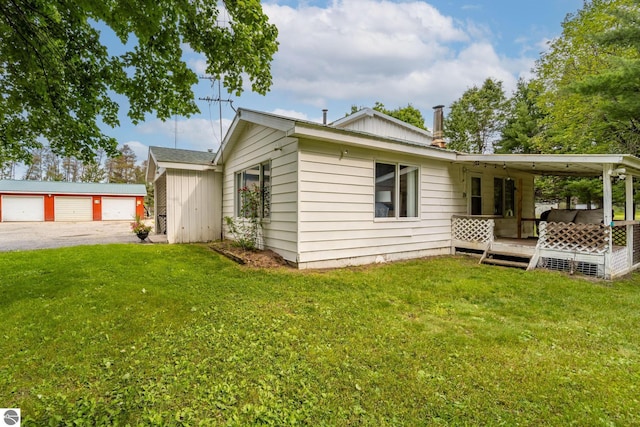 view of property exterior with an outbuilding, a yard, and driveway