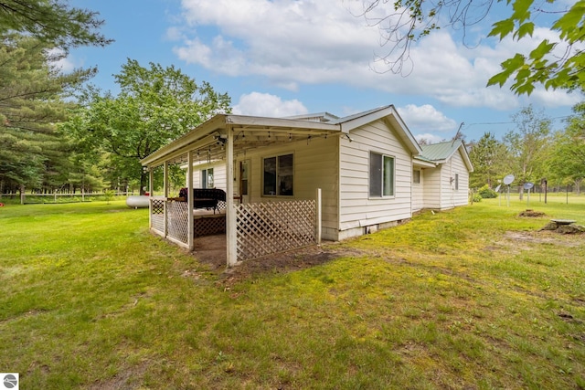 view of side of home with a patio area and a lawn