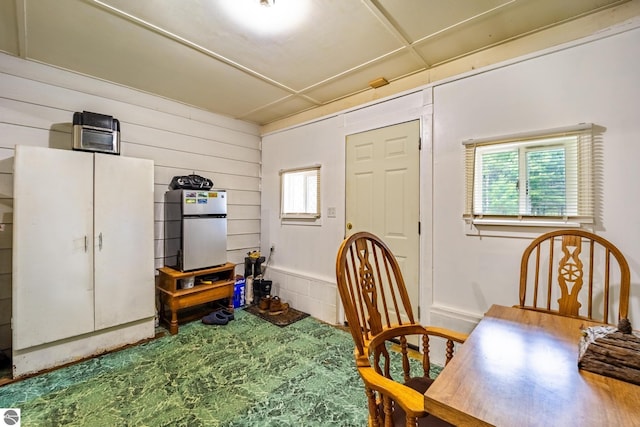 dining space featuring wooden walls