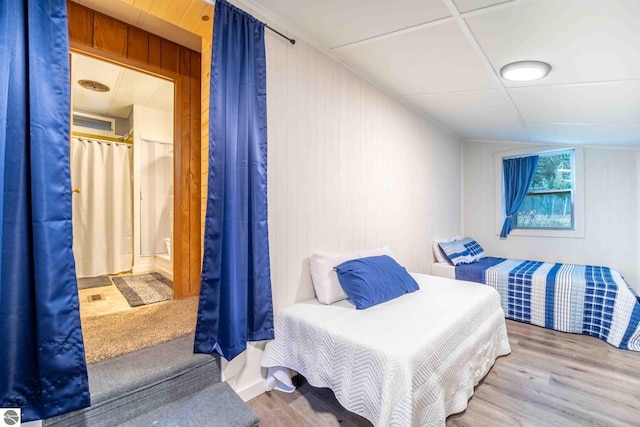 bedroom featuring wood walls and wood finished floors