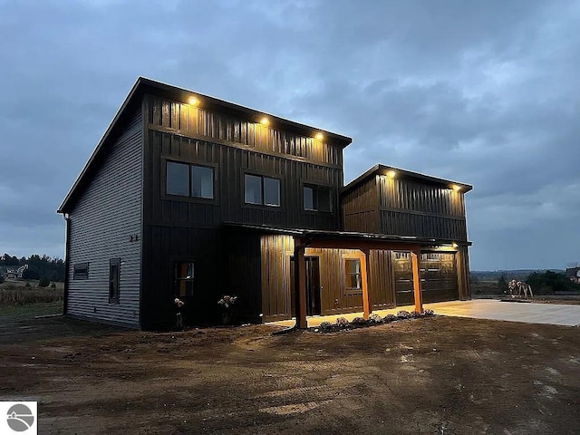 rear view of house with driveway and board and batten siding