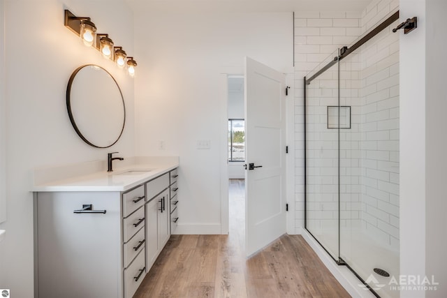 full bath featuring a stall shower, wood finished floors, and vanity