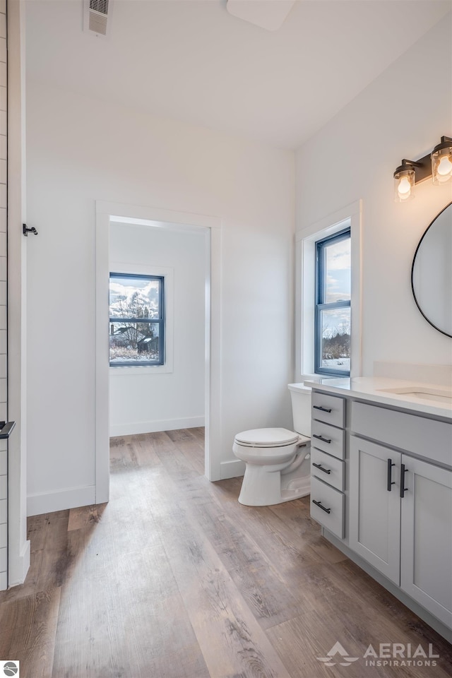 bathroom featuring a healthy amount of sunlight, visible vents, toilet, and wood finished floors