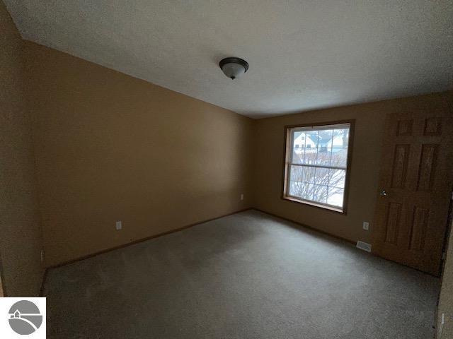 unfurnished room featuring carpet floors and visible vents