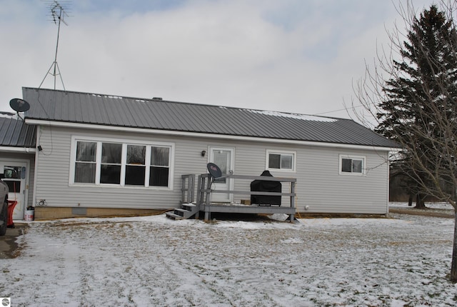 snow covered house featuring metal roof