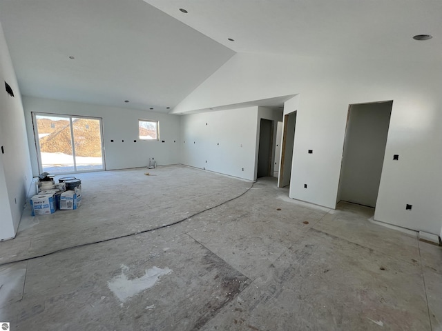 unfurnished living room with high vaulted ceiling