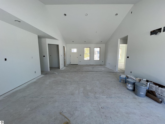 unfurnished living room featuring high vaulted ceiling