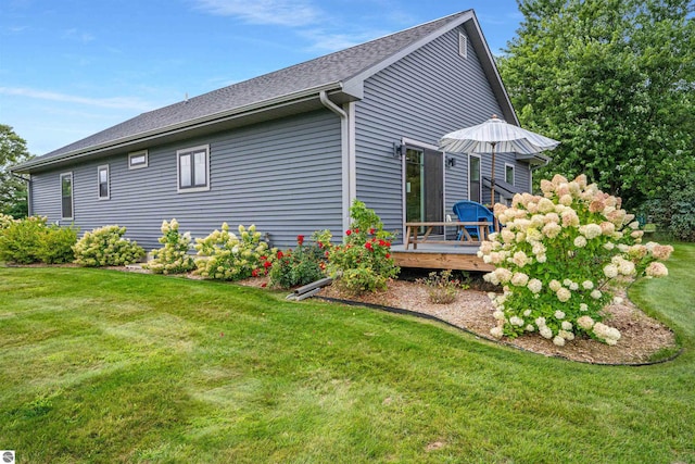 view of property exterior with a yard and a deck