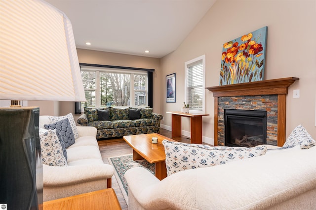 living room featuring vaulted ceiling, wood finished floors, a fireplace, baseboards, and recessed lighting