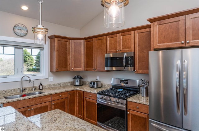 kitchen featuring brown cabinets, stainless steel appliances, and a sink