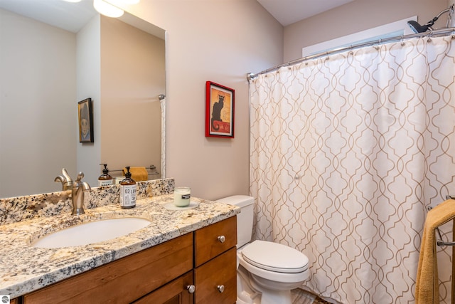 bathroom featuring a shower with shower curtain, toilet, and vanity