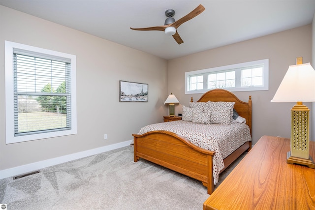 carpeted bedroom featuring ceiling fan, baseboards, and visible vents