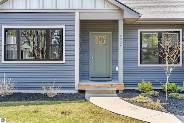 entrance to property featuring a shingled roof