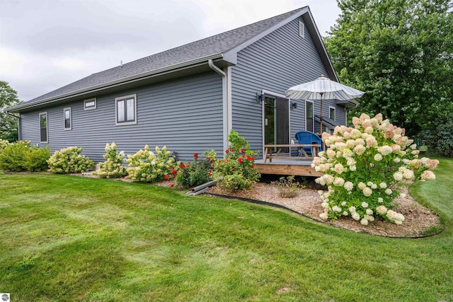 view of property exterior with a lawn and a deck
