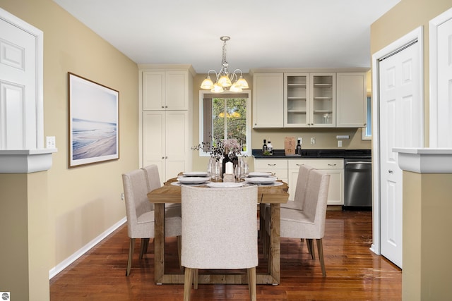 dining space featuring an inviting chandelier, baseboards, and dark wood finished floors