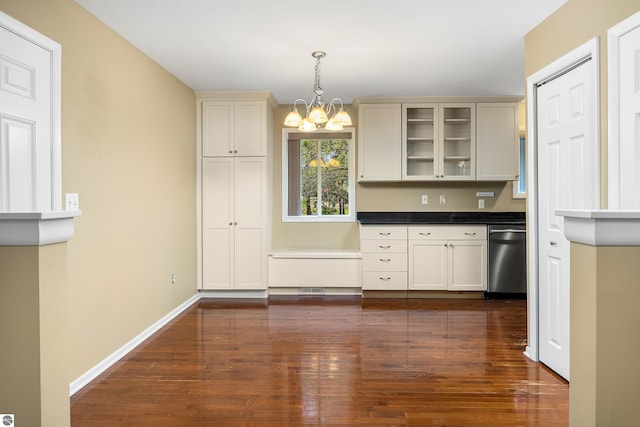 kitchen featuring stainless steel dishwasher, dark wood-type flooring, glass insert cabinets, and an inviting chandelier