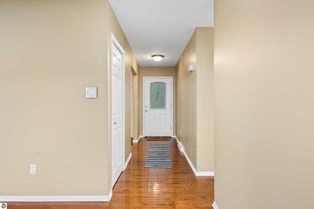 doorway to outside with wood finished floors and baseboards