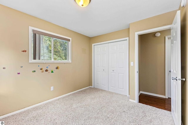 unfurnished bedroom featuring carpet, a closet, and baseboards