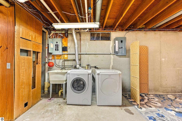 washroom with laundry area, electric panel, independent washer and dryer, and a sink