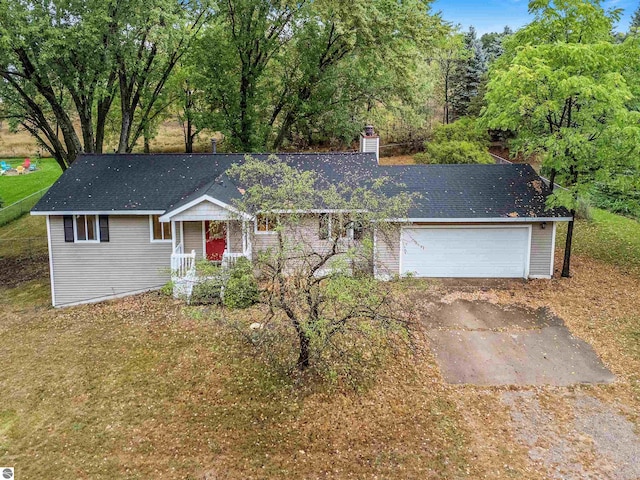 ranch-style home with a garage, driveway, a chimney, and a front yard