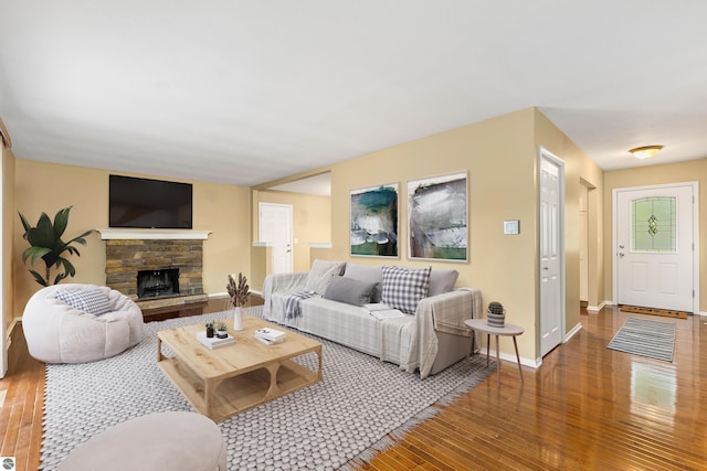 living room with hardwood / wood-style flooring, a fireplace, and baseboards