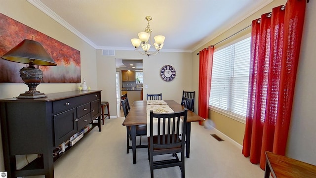 dining room featuring a chandelier, light carpet, crown molding, and visible vents