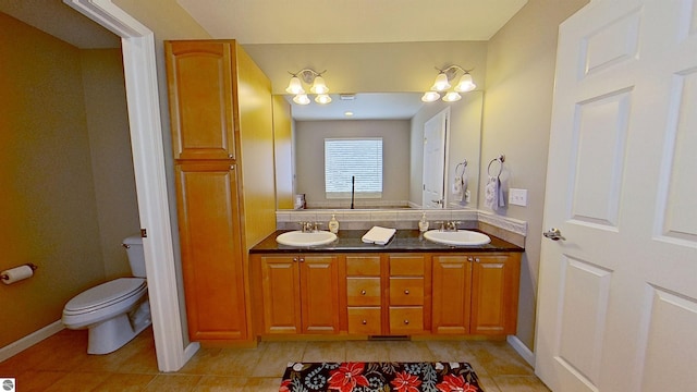 full bath with double vanity, tile patterned flooring, a sink, and toilet