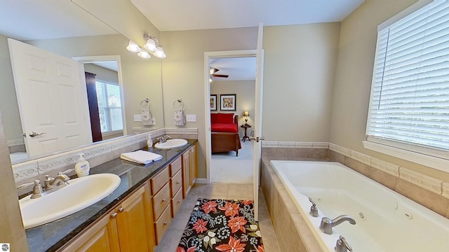 bathroom with double vanity, tile patterned flooring, a tub with jets, and a sink