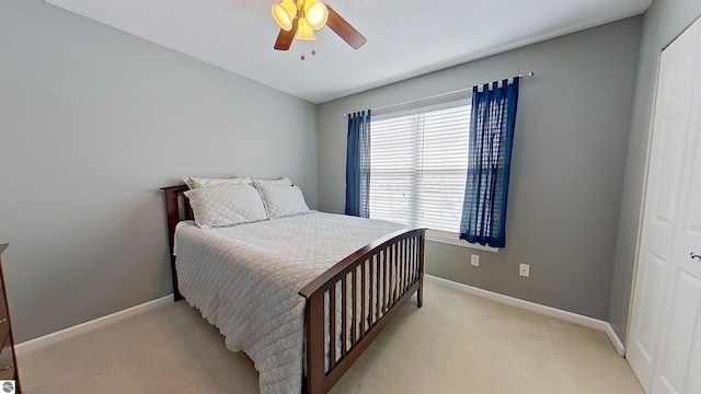 bedroom featuring a ceiling fan, light colored carpet, and baseboards