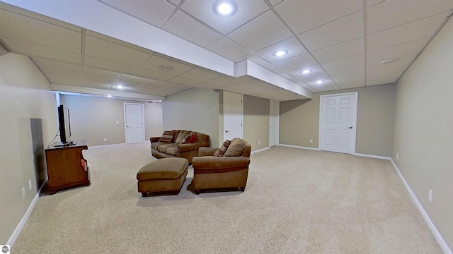 carpeted living area featuring a paneled ceiling, baseboards, and recessed lighting