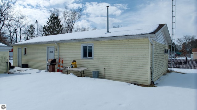 snow covered house with fence