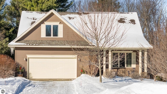 view of front of home with a garage and a shingled roof