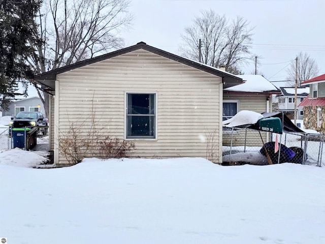 snow covered property featuring fence