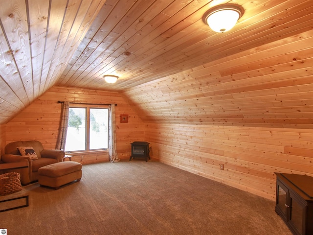 additional living space with lofted ceiling, wood ceiling, wood walls, and carpet