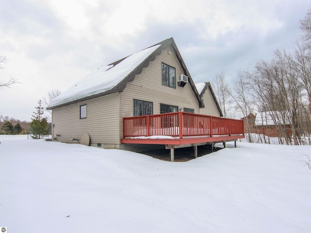 snow covered rear of property featuring a deck and crawl space