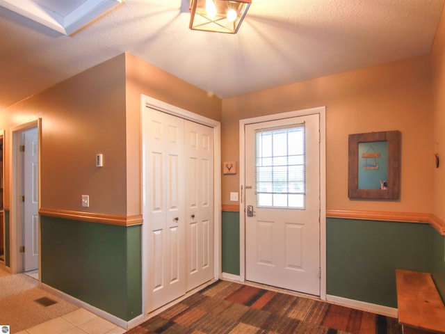 foyer entrance with visible vents, baseboards, and wood finished floors