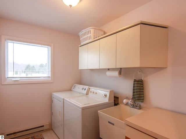 laundry room with cabinet space, a baseboard heating unit, washer and clothes dryer, and a sink