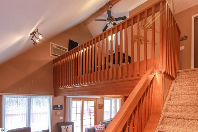 stairs with high vaulted ceiling, a wall mounted air conditioner, beamed ceiling, and a ceiling fan