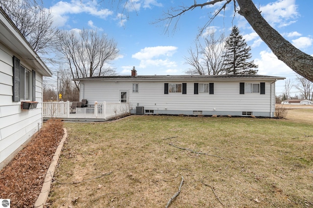 back of property with cooling unit, a lawn, a chimney, and a wooden deck