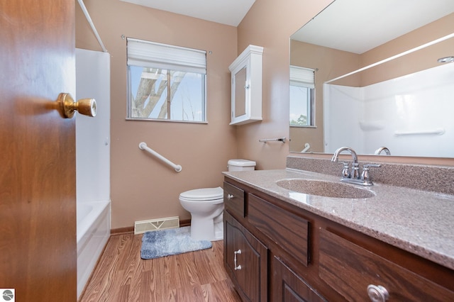 bathroom with baseboards, visible vents, toilet, wood finished floors, and vanity