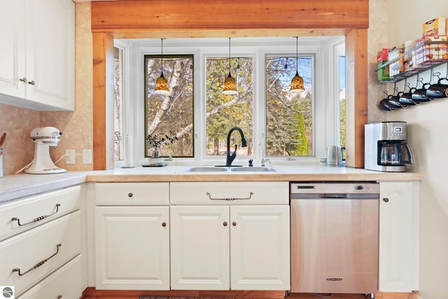 kitchen with a sink, white cabinetry, light countertops, and dishwasher