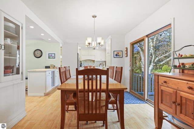 dining room featuring a chandelier, recessed lighting, and light wood-style floors