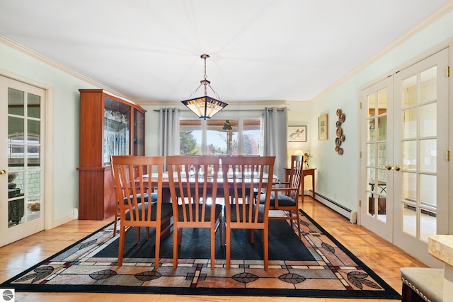 dining space with a baseboard heating unit, wood finished floors, crown molding, and french doors