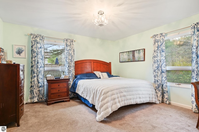 bedroom with an inviting chandelier, baseboards, and carpet flooring