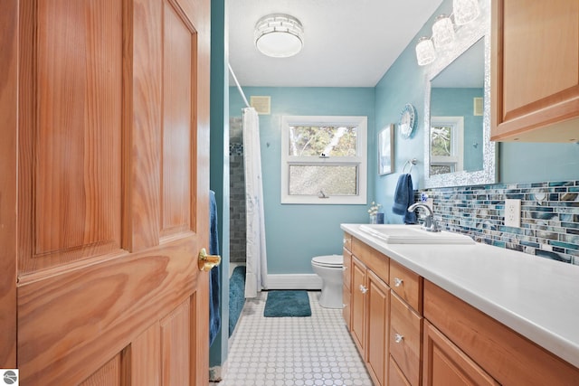 bathroom featuring tasteful backsplash, visible vents, toilet, vanity, and baseboards