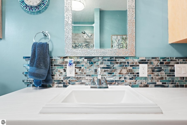 full bathroom with a tile shower, backsplash, and a sink